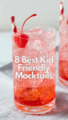 two glasses filled with red liquid and straws on top of a white table cloth