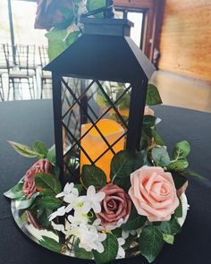 a table with a lantern and flowers on it