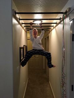 a person jumping up into the air in an apartment hallway with wires running all around