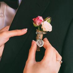 a person in a tuxedo is holding a small vase with flowers on it