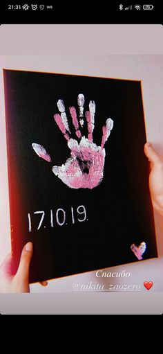 someone is holding up a handprinted card for their child's birth