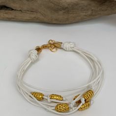 8 1/4 Inch In Length Including Jump Rings For Adjustment. White Cording With Gold Colored Beads. Newly Made Everyday White Hand-wrapped Jewelry, Everyday White Jewelry With Spacer Beads, White Gold Beads Bracelet, Hand Wrapped White Round Bead Jewelry, Adjustable White Bracelets With Gold Beads, White Multi-strand Bracelet As Gift, Adjustable White Beaded Bracelets With Gold Beads, White Multi-strand Beaded Bracelets As Gift, White Multi-strand Bracelets For Jewelry Making