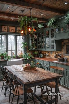 a kitchen with green cabinets and wooden table surrounded by chairs, potted plants on the counter