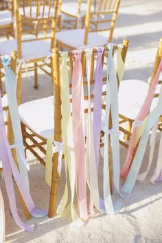 the chairs are lined up with ribbons on them