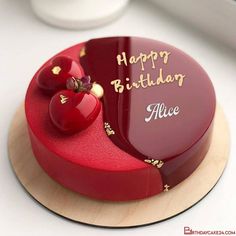 a red birthday cake with two hearts on it's top and the words happy birthday alice written in gold