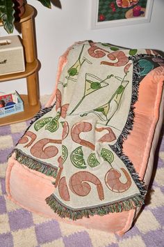 a chair with a blanket on top of it in front of a potted plant