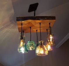 a light fixture with five glass bottles hanging from it