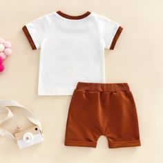 Set with a short sleeve top and short bottoms in soft, cotton fabric. Top has "Mama's Boy" with a retro style font and colored edge hems. Shorts with drawstring waistband and middle pocket. The cutest outfit for your little mama's boy!   Pieces: 2 Length: Short Sleeve length: Short Style: Set Neckline: Round Neck Mater Brown Cotton Playwear Set, Playful Solid Color Cotton Sets, Casual Brown Playwear Sets, Casual Solid Color Cotton Short Set, Family Matching Cotton Sets With Short Sleeves, Casual Cotton Short Set For Playtime, Cute Brown Cotton Set, Playful Brown Cotton Sets, Cotton Short Sleeve Set With Letter Print