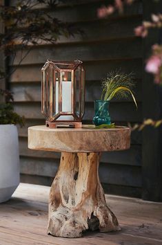 a wooden table with a candle and vase on it