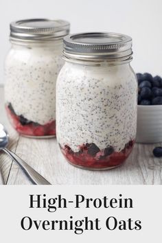 two mason jars filled with overnight oats on top of a wooden table next to blueberries