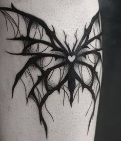 a black and white photo of a butterfly tattoo on the leg, which is shaped like a heart