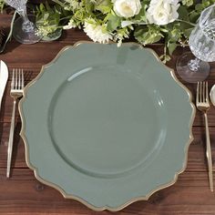 a table setting with plates, silverware and flowers on the place settings for an elegant dinner