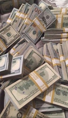 a pile of money sitting on top of a bed