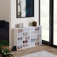 a living room with a white shelf filled with shoes