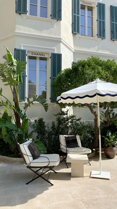 two chairs and an umbrella in front of a building