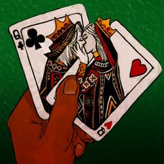 a hand holding two playing cards in front of a green background with the queen and king of spades