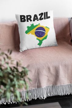 a couch with a pillow that has the brazilian flag on it and is next to a potted plant