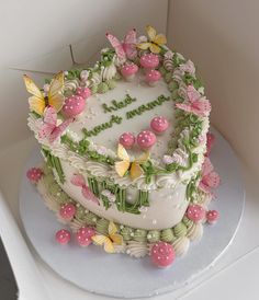 a birthday cake decorated with butterflies and flowers