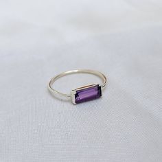 BAGUETTE AMETHYST RING Gemstone: Amethyst Quartz Material: Solid 925 Sterling Silver Base Metal: 18K Gold, Sterling Silver Shape: Baguette Color: Purple Stone Size: 10X4 mm PLEASE NOTE: - We use good quality gemstone. Therefore they might vary a little in color, hue and reflection. But i assure you will like it. We use base material 925 solid silver then gold plating or rose gold on the ring. If you will do care the ring of gold plating it will go last longer. SHOP JEWELLERYVILLA> https://www.et Minimalist Amethyst Birthstone Ring For Anniversary, Purple Sterling Silver Minimalist Jewelry, Dainty Amethyst Gemstone Stackable Rings, Minimalist Amethyst Gemstone Ring For Gift, Minimalist Amethyst Gemstone Ring Gift, Minimalist Amethyst Gemstone Ring, Minimalist Purple Sterling Silver Jewelry, Minimalist Amethyst Birthstone Promise Ring, Minimalist Sterling Silver Crystal Ring With Bezel Setting