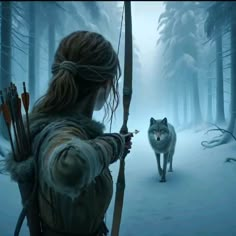 a woman holding a bow while standing next to a wolf