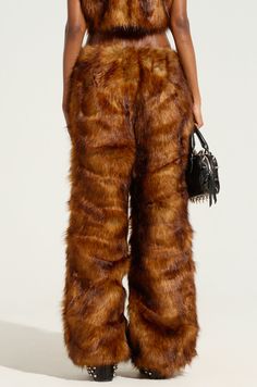 Haters will be furr-ious when they see you rocking The AKIRA Label Jodie Wide Leg Fashion Fur Pant. This editorial trouser is crafted from impossibly soft faux fur and features a relaxed mid-rise fit, a slick satin inner lining, and a concealed side zipper closure. Style with the complementary Wild Child Cropped Fur Vest for a luxe look from head to toe.  - Main: 80% Acrylic, 20% Polyester, Lining: 95% Polyester, 5% Spandex - No Stretch- Imported (all measurements approximate from size small) - 42” Waist to Hem- 30” Inseam - 12” Rise- Model is 5’8” and wearing a size small Product ID: 434918 Fur Pants, Black Leather Pants, Wild Child, Fur Vest, Side Zipper, See You, Casual Pants, Leather Pants, Mid Rise