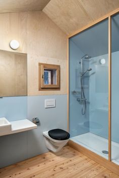 a bathroom with a toilet, sink and shower stall in the middle of the room