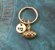 a football keychain with the number 12 on it and a ball charm attached to it