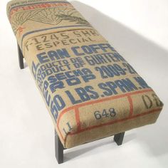 a bench made out of burlap and wood with an advertisement on the back