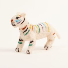 a white stuffed animal with multicolored stripes on it's body and legs