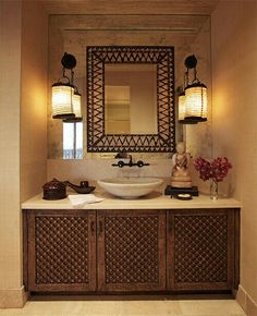 a bathroom with a sink, mirror and two lights on the side of the wall