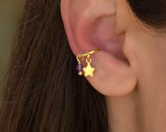 a close up of a person wearing a pair of ear clips with stars on them