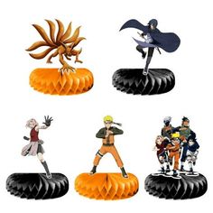 some anime figurines sitting on top of an orange piece of paper in front of a white background