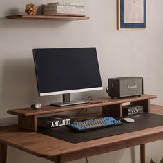 a computer monitor sitting on top of a wooden desk next to a keyboard and mouse