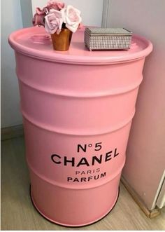 a pink trash can with flowers on top and the number 5 chanel paris parfum