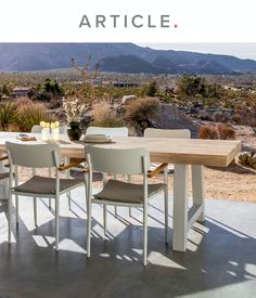 a table and chairs with the words article written below it in front of an image of mountains