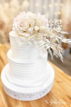 a white wedding cake with flowers on top