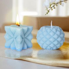 two blue candles sitting next to each other on a table