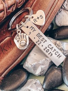 a keychain with a tag on it sitting next to some rocks and stones