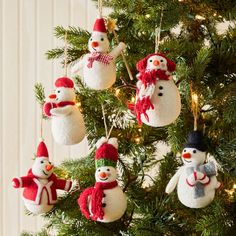 snowman ornaments hanging from a christmas tree