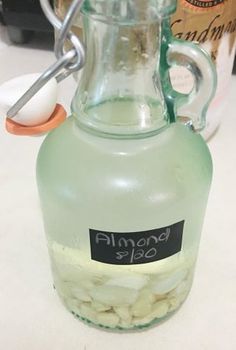 a glass jug filled with almonds on top of a table