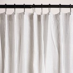 a white and black striped curtain hanging from a metal rod