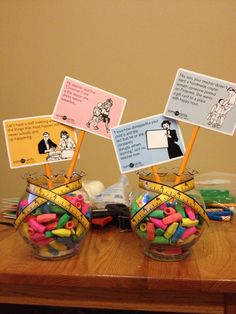 two glass bowls filled with candy on top of a wooden table