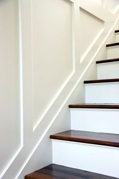 some white stairs with wood handrails in a house