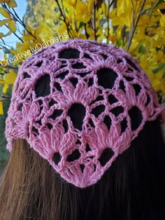 the back of a woman's head wearing a pink crochet hat