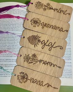 four wooden bookmarks with the names of three different books on top of each other