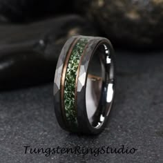 a wedding ring with green moss inlays on the inside and black wood inlay