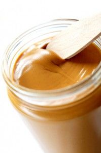 a spoon in a jar filled with peanut butter