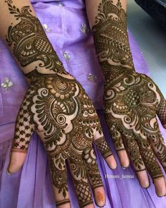 a woman's hands with henna tattoos on it