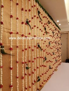 the wall is decorated with red flowers and white string work on it's sides