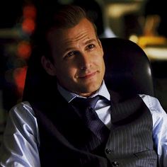 a man in a vest and tie sitting at a desk